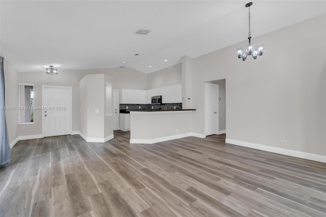 1592 Salerno Cir, Weston, FL 33327 - unfurnished living room with lofted ceiling, wood finished floors, and a chandelier