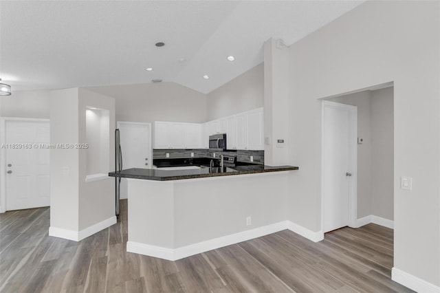 1592 Salerno Cir, Weston, FL 33327 - kitchen with stainless steel microwave, white cabinets, dark countertops, wood finished floors, and backsplash