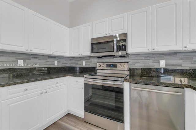 1592 Salerno Cir, Weston, FL 33327 - kitchen with stainless steel appliances, white cabinetry, decorative backsplash, and light wood finished floors
