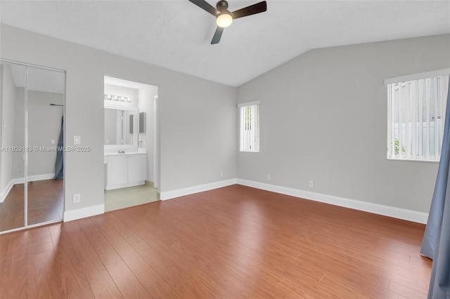 1592 Salerno Cir, Weston, FL 33327 - unfurnished bedroom with vaulted ceiling, wood finished floors, a closet, ensuite bath, and a ceiling fan