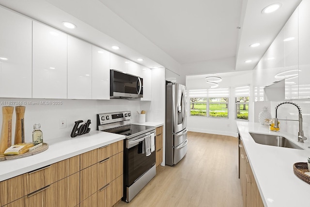 550 SW 138th Ave Unit 112K, Pembroke Pines, FL 33027 - kitchen featuring appliances with stainless steel finishes, modern cabinets, light wood-type flooring, white cabinets, and recessed lighting