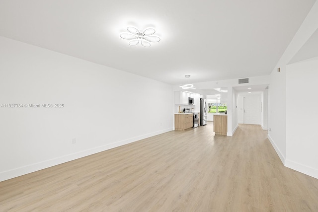 550 SW 138th Ave Unit 112K, Pembroke Pines, FL 33027 - unfurnished living room featuring baseboards and light wood finished floors
