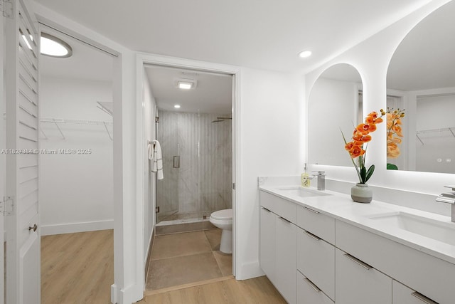 550 SW 138th Ave Unit 112K, Pembroke Pines, FL 33027 - bathroom with a marble finish shower, double vanity, wood finished floors, a spacious closet, and recessed lighting