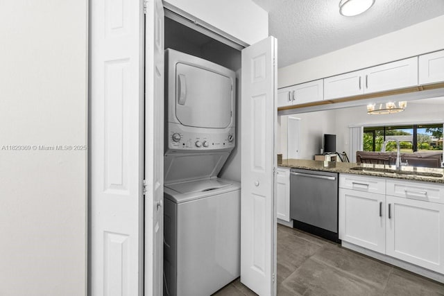 3693 N Arelia Dr N, Delray Beach, FL 33445 - washroom with stacked washer / dryer, a chandelier, and a textured ceiling