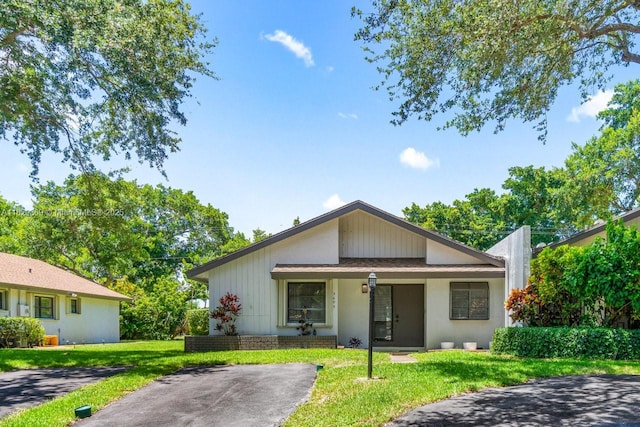 3693 N Arelia Dr N, Delray Beach, FL 33445 - view of front of property featuring a front lawn and covered porch
