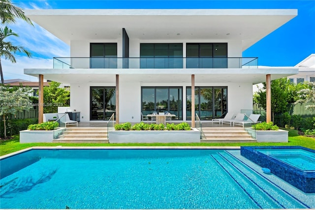 1410 S Biscayne Point Rd, Miami Beach, FL 33141 - back of property with a balcony, a patio, stucco siding, and a pool with connected hot tub