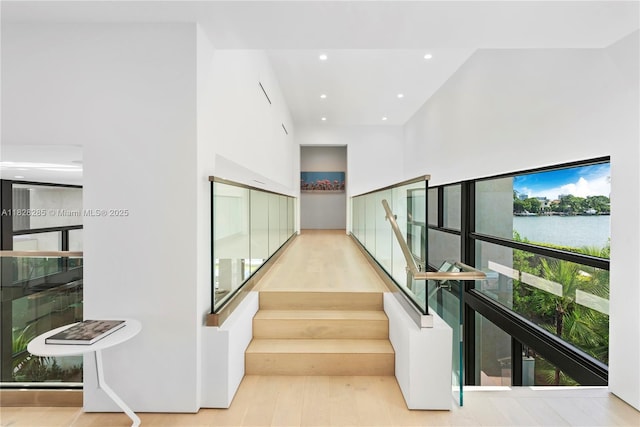 1410 S Biscayne Point Rd, Miami Beach, FL 33141 - stairs featuring a towering ceiling, a water view, recessed lighting, and wood finished floors