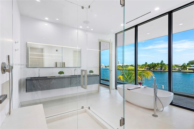 1410 S Biscayne Point Rd, Miami Beach, FL 33141 - bathroom with a freestanding bath, a wall of windows, tile patterned floors, recessed lighting, and a water view