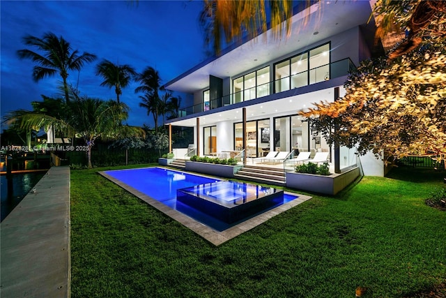 1410 S Biscayne Point Rd, Miami Beach, FL 33141 - rear view of house with a balcony, a yard, stucco siding, a pool with connected hot tub, and a patio