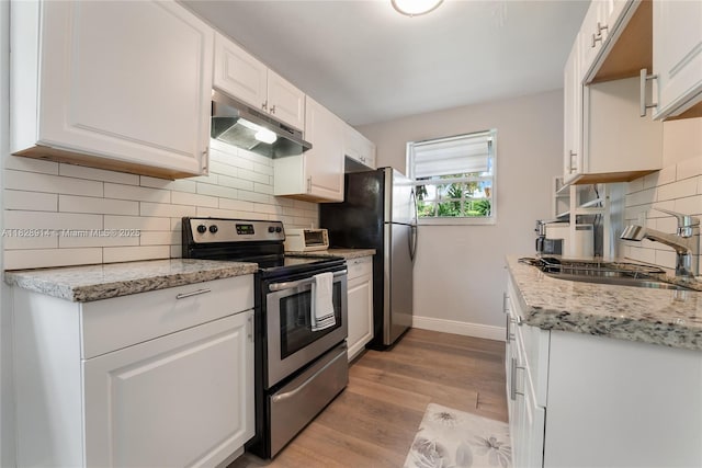 6198 SW 63rd St, South Miami, FL 33143 - kitchen with stainless steel appliances, under cabinet range hood, white cabinets, and light wood-style flooring