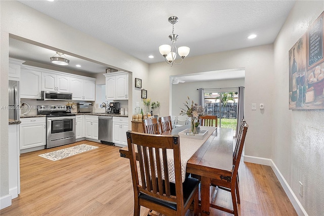 3301 NW 42nd St, Lauderdale Lakes, FL 33309 - dining space featuring light wood-style floors, a chandelier, a textured ceiling, and recessed lighting