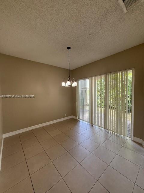 3736 SW 50th St, Hollywood, FL 33312 - spare room with healthy amount of natural light, a chandelier, a textured ceiling, and light tile patterned floors