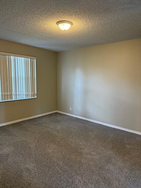 3736 SW 50th St, Hollywood, FL 33312 - spare room featuring dark carpet and a textured ceiling