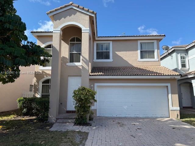 3736 SW 50th St, Hollywood, FL 33312 - view of front of house with stucco siding, a garage, a tile roof, and decorative driveway