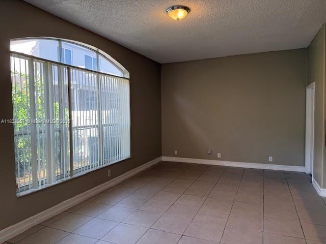 3736 SW 50th St, Hollywood, FL 33312 - tiled empty room featuring a textured ceiling