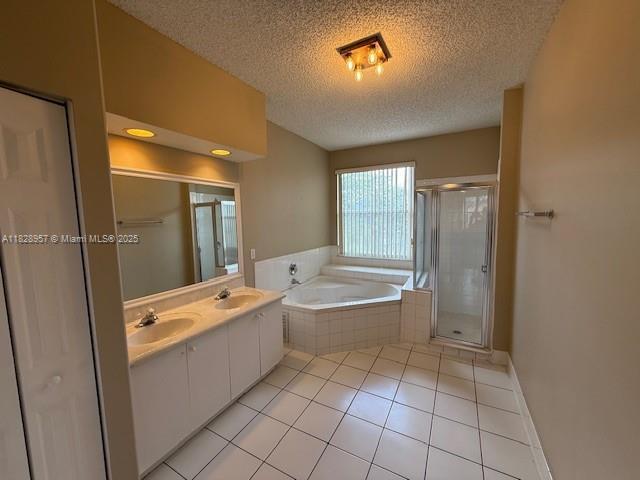 3736 SW 50th St, Hollywood, FL 33312 - bathroom with a textured ceiling, a garden tub, a stall shower, double vanity, and tile patterned flooring