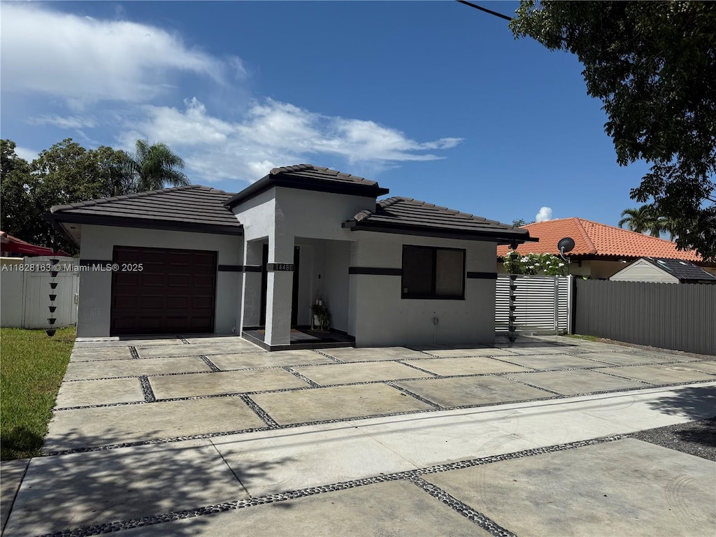 14480 SW 112th St, Miami, FL 33186 - prairie-style home with stucco siding, a garage, a tiled roof, and driveway