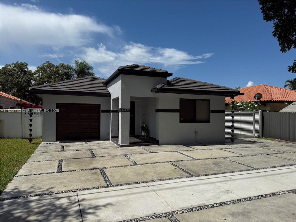 14480 SW 112th St, Miami, FL 33186 - view of front of house featuring stucco siding, a garage, driveway, and a tiled roof