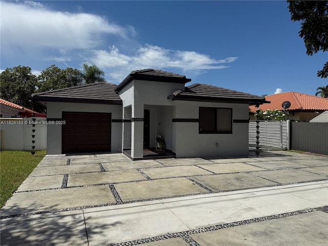 14480 SW 112th St, Miami, FL 33186 - prairie-style house featuring stucco siding, driveway, an attached garage, and a tiled roof