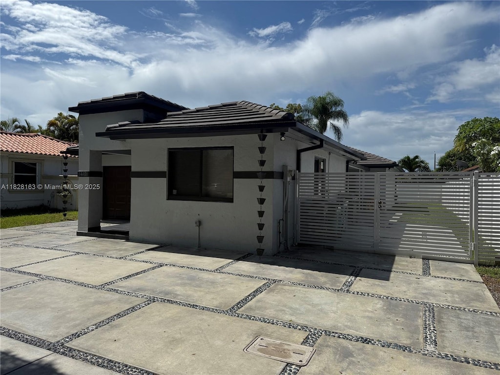 14480 SW 112th St, Miami, FL 33186 - back of house featuring stucco siding, a tiled roof, a gate, and a patio