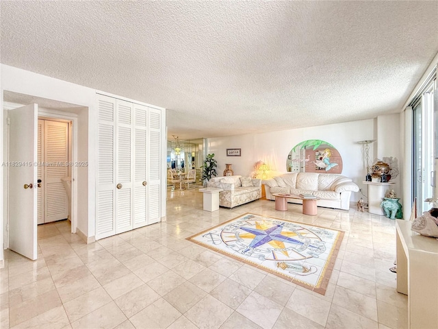 5701 Collins Ave Unit 417, Miami Beach, FL 33140 - living room featuring a textured ceiling and a chandelier