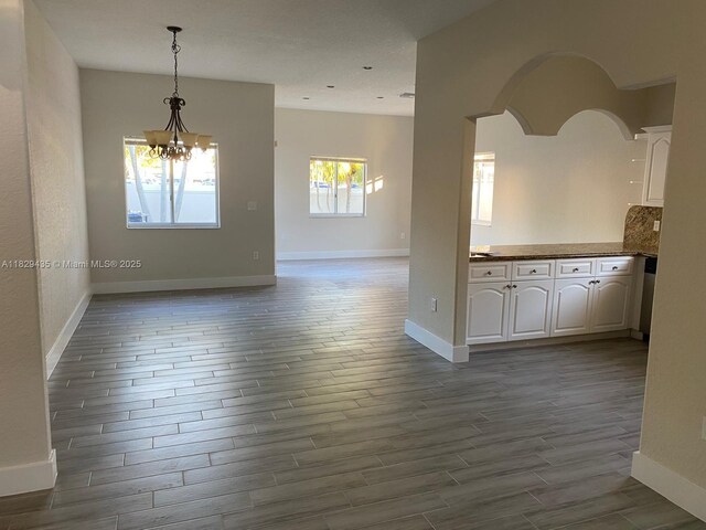 5521 SW 158th Ct, Miami, FL 33185 - spare room with dark wood-style flooring, a chandelier, and arched walkways