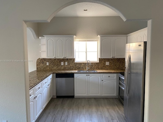 5521 SW 158th Ct, Miami, FL 33185 - kitchen featuring stainless steel appliances, open shelves, arched walkways, and light wood-style flooring