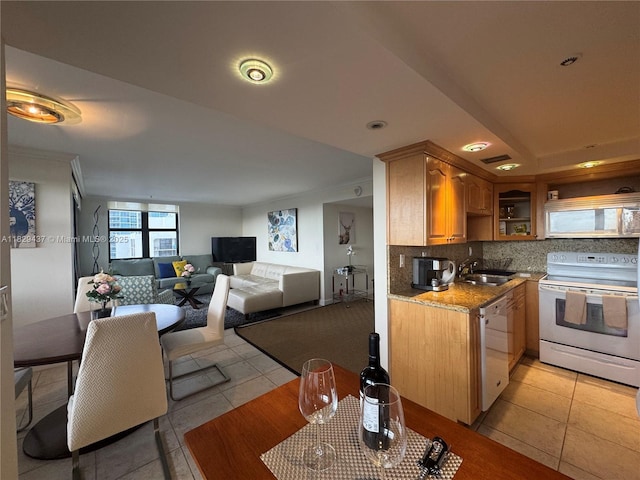 2555 Collins Ave Unit 2002, Miami Beach, FL 33140 - kitchen with white appliances, light tile patterned floors, decorative backsplash, light stone countertops, and open floor plan