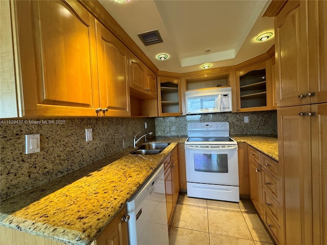 2555 Collins Ave Unit 2002, Miami Beach, FL 33140 - kitchen featuring white appliances, light stone countertops, light tile patterned floors, and brown cabinets