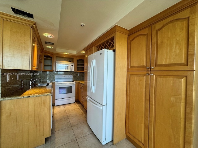 2555 Collins Ave Unit 2002, Miami Beach, FL 33140 - kitchen with white appliances, tasteful backsplash, brown cabinets, glass insert cabinets, and light tile patterned floors