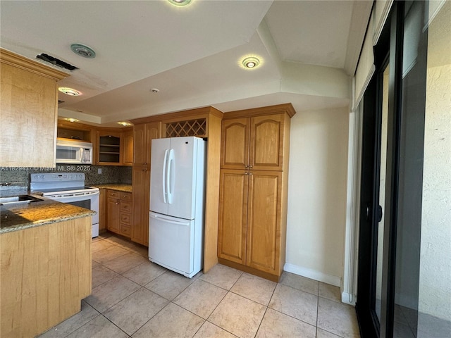 2555 Collins Ave Unit 2002, Miami Beach, FL 33140 - kitchen with white appliances, backsplash, light tile patterned floors, brown cabinets, and stone counters