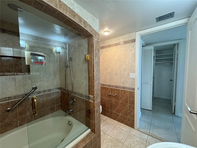 2555 Collins Ave Unit 2002, Miami Beach, FL 33140 - full bathroom with tile patterned flooring, tiled shower / bath, tile walls, and a closet