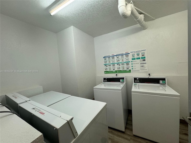 2555 Collins Ave Unit 2002, Miami Beach, FL 33140 - shared laundry room with dark wood-style flooring, washer and dryer, a textured ceiling, and a textured wall