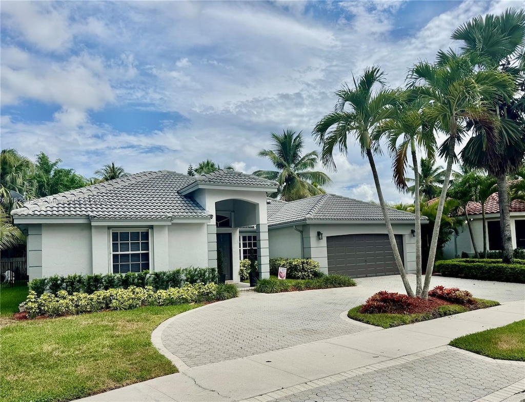 2587 Jardin Ct, Weston, FL 33327 - view of front of house with a tile roof, stucco siding, decorative driveway, and a garage