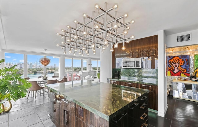 900 Bay Dr Unit 702/704, Miami Beach, FL 33141 - kitchen featuring stainless steel microwave, a chandelier, modern cabinets, and pendant lighting