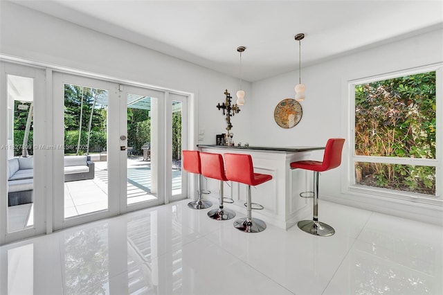 5055 N Bay Rd, Miami Beach, FL 33140 - indoor dry bar featuring tile patterned floors, plenty of natural light, and hanging light fixtures