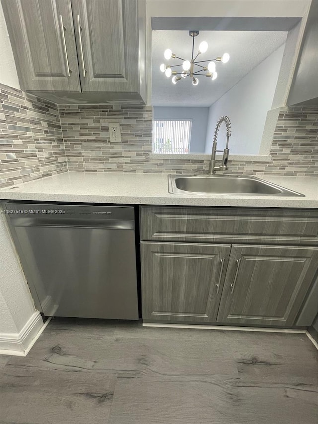 365 NE 125th St Unit 302, North Miami, FL 33161 - kitchen featuring stainless steel dishwasher, a chandelier, backsplash, light countertops, and light wood finished floors