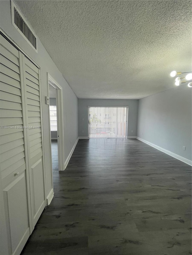 365 NE 125th St Unit 302, North Miami, FL 33161 - unfurnished room with a textured ceiling, dark wood-style flooring, and a chandelier