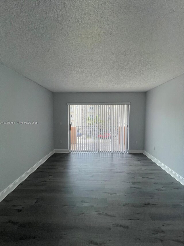365 NE 125th St Unit 302, North Miami, FL 33161 - unfurnished room with dark wood-style flooring and a textured ceiling