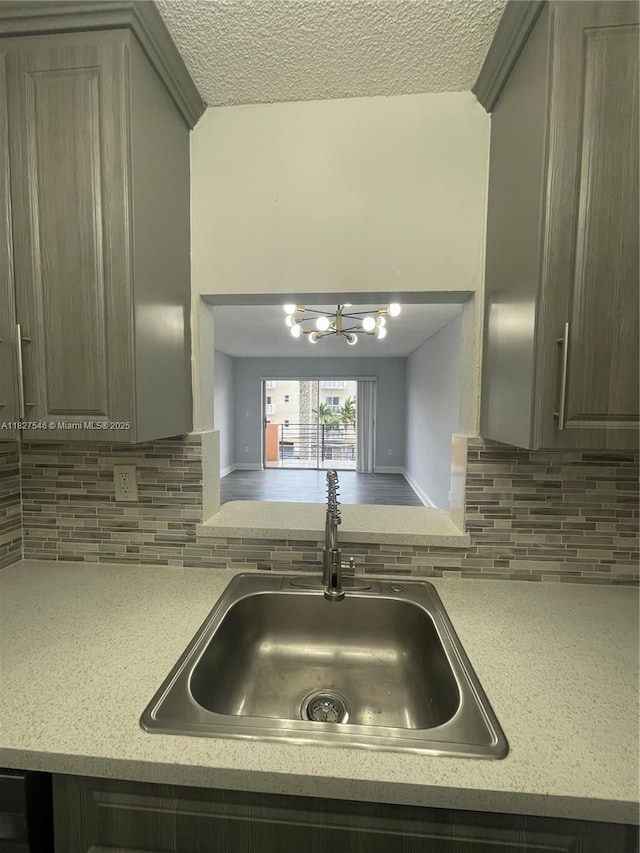 365 NE 125th St Unit 302, North Miami, FL 33161 - kitchen with a chandelier, light countertops, a textured ceiling, and backsplash