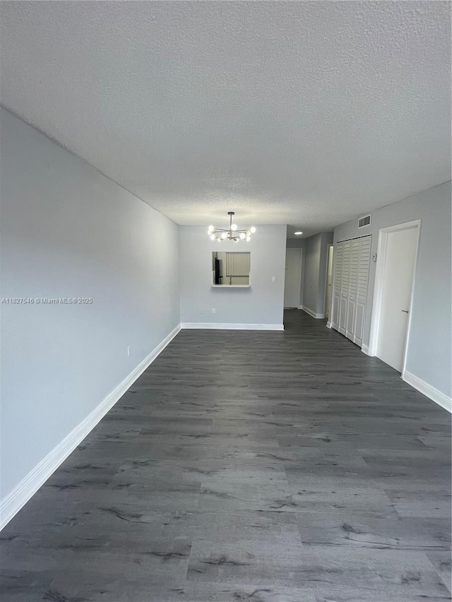 365 NE 125th St Unit 302, North Miami, FL 33161 - unfurnished living room featuring a chandelier, a textured ceiling, and dark wood finished floors
