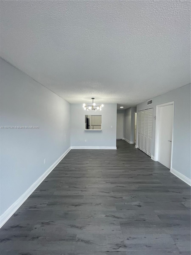 365 NE 125th St Unit 302, North Miami, FL 33161 - unfurnished living room with a chandelier, dark wood-style floors, and a textured ceiling