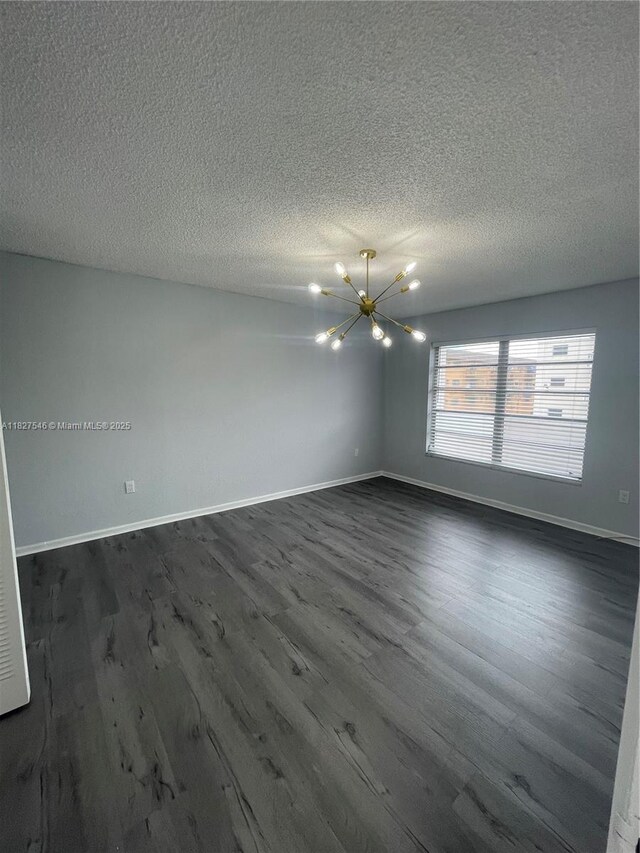 365 NE 125th St Unit 302, North Miami, FL 33161 - spare room featuring a chandelier, dark wood finished floors, and a textured ceiling