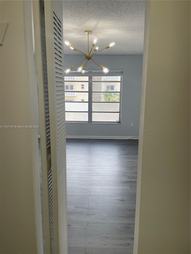 365 NE 125th St Unit 302, North Miami, FL 33161 - spare room with a chandelier, wood finished floors, and a textured ceiling