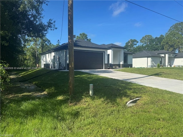 3003 18th St W, Lehigh Acres, FL 33976 - view of front of home with a front lawn, an attached garage, concrete driveway, and stucco siding