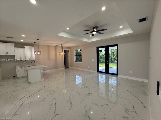 3003 18th St W, Lehigh Acres, FL 33976 - unfurnished living room featuring recessed lighting, ceiling fan, a raised ceiling, light marble finish flooring, and a chandelier