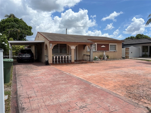 851 W 35th St, Hialeah, FL 33012 - ranch-style house featuring stucco siding, a carport, a gate, and covered porch