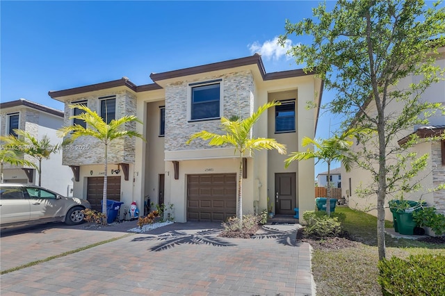 25483 SW 109th Ave, Homestead, FL 33032 - view of front facade with an attached garage, decorative driveway, stucco siding, and stone siding