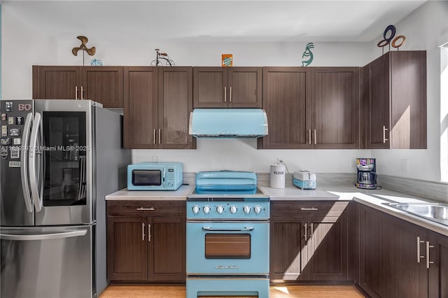 25483 SW 109th Ave, Homestead, FL 33032 - kitchen featuring appliances with stainless steel finishes, exhaust hood, light countertops, and dark brown cabinetry