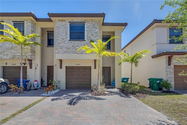 25483 SW 109th Ave, Homestead, FL 33032 - view of property with stone siding, stucco siding, decorative driveway, and a garage